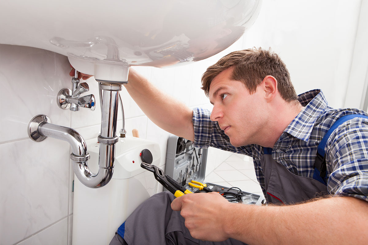 Plumber fixing the sink