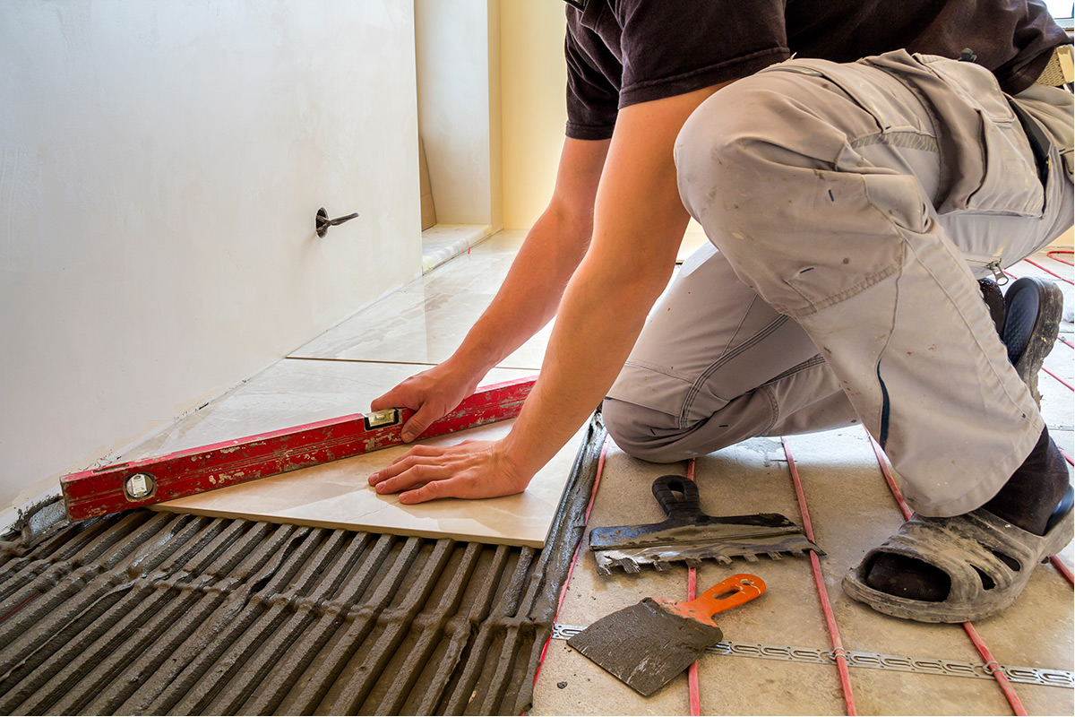 A tiler putting tiles on the floor